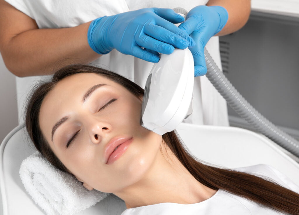 A Lady Getting Lumecca IPL Treatment through a Device | Aesthetic Arts Medical Spa and Wellness in Great Neck, NY